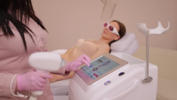 女性美容师在美容院使用激光消光机 美容院的治疗师检查激光脱毛机 — 图库视频影像