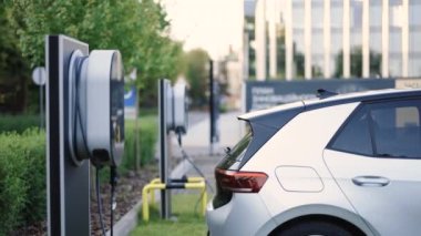 Charge station for electric cars. Electric car charger. Alternative energy for ecological cars. Electric, zero pollution cars on green energy concept on modern city parking lot.
