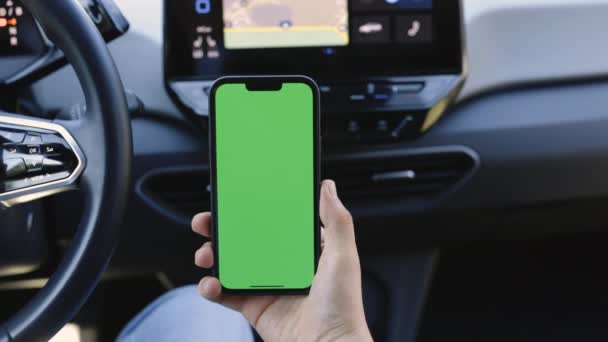 一名男子手牵着一部带有垂直绿色屏幕的手机 手持汽车着色键智能手机技术手机街道触摸屏显示手 — 图库视频影像
