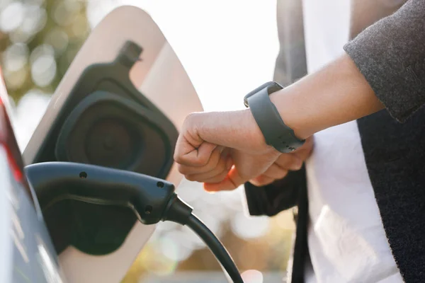 Unrecognizable Man Disconnects Charging Cable Electric Vehicle Using Smartwatch Male — Stok fotoğraf