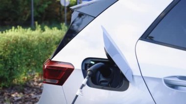 Elektrikli araba şarj oluyor. Elektrikli araç, arabanın fişini takıyor. Şarj teknolojisi, temiz enerji doldurma teknolojisi..