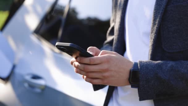 Jeune Homme Utilisant Smartphone Près Voiture Électrique Sur Borne Recharge — Video
