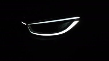 Farlar gece araba LED farlarını açıyor. Yeni modern elektrikli araba farları. Aracın ön tarafındaki IQ ışığını kapat. Arkaplanı bulanık..