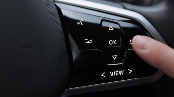 汽车内部的特写镜头 汽车控制音乐方向盘视图 司机按方向盘上汽车收音机的音量按钮 把车内的音乐音量调大 — 图库视频影像