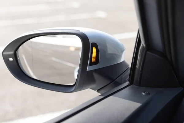 System blind spots of the car. Detail of side keeping assist system switch button. Blind zone monitoring sensor on the side mirror of a modern electric car.