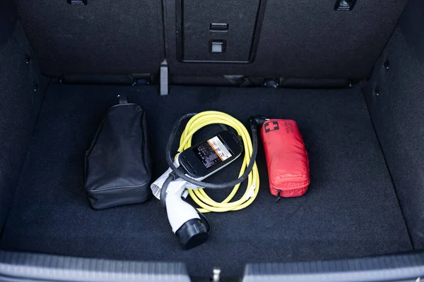 Electric car charger in car trunk. Car trunk with charging cables. Modern car interior. Portable in-cable charging box for electric car charging lying in car trunk