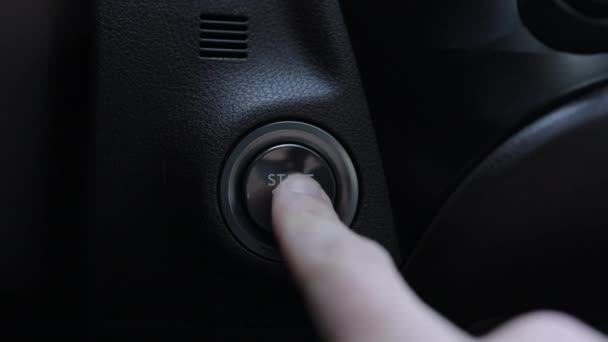自動車エンジンスタート フィンガーは車のエンジンを始めるためにボタンを押します ボタンにトラックインします スタート停止点火ボタンを押してキーレス点火ハイブリッド車の電気エンジンを開始 — ストック動画