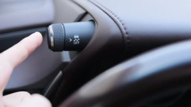 ESP düğmesi elektronik denge programı kontrolü. Modern bir arabanın iç dekorasyonu. Sürücüler gösterge panelindeki Çekiş Kontrol Sistemi düğmesine parmak basıyor. Çekiş Kontrol Sistemi kapalı.