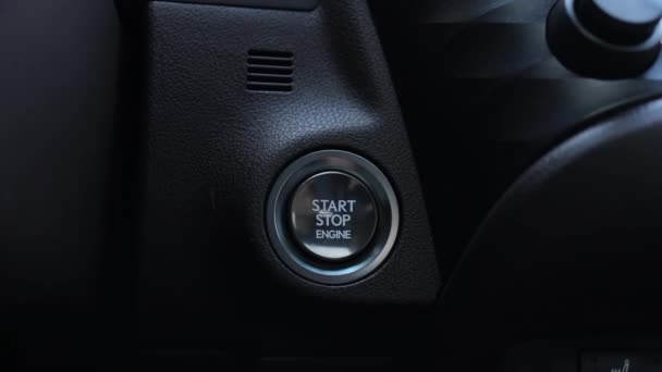 フィンガーは車のエンジンを始めるためにボタンを押します ドライバーの手が車のスタートボタンを押しています 自動車エンジンスタート ボタンにトラックインします 輸送と技術のコンセプト — ストック動画