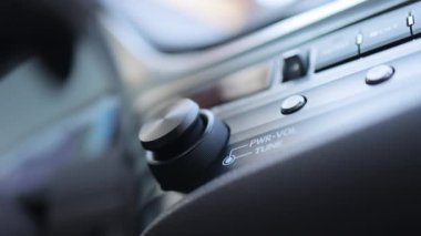 Araba gösterge paneli ses düğmesi. Sürücü el, araba radyosunun ses kontrolünü ayarlar. Erkek el kumandalı radyo ya da hareket halindeki müzik. Arabadaki müziğin sesini açar.