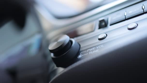 汽车仪表盘音量旋钮 驾驶员手工调整汽车收音机的音量控制 驾驶汽车的男性手控收音机或音乐 把车内的音乐音量调大 — 图库视频影像