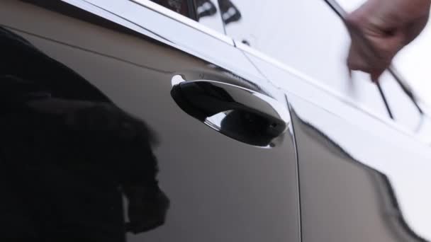 一个男人 一个司机 一个买主打开司机座位的门 躲到一辆新车的方向盘后面 关上车门 无法辨认的人在经销店买汽车 成功与生活方式 — 图库视频影像