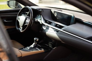 Prestijli modern araba. Arabanın içinde deri koltuklar, direksiyon, pencereler, konsol, vites kolu, elektrik düğmeleri, dijital hız göstergesi var. Lüks araba iç mekanı. Araba temizleme serisi.