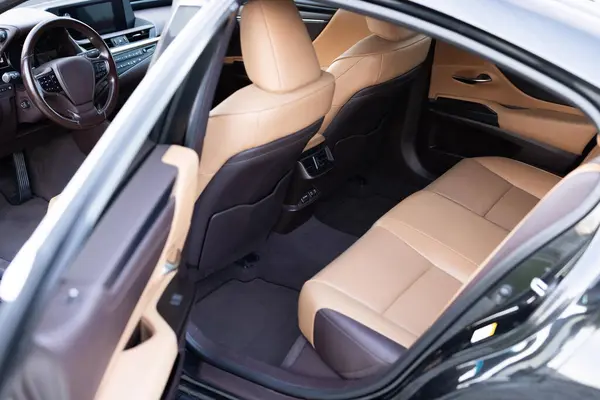Rear leather passenger seats in modern lux car. Leather car passenger seat. Control unit with electric seat adjustment media system for rear passengers in luxury car. Modern car interior detail.