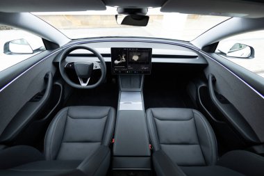 Lviv, Ukrayna - 23 Mart 2024: İç Tesla Model 3 Highland elektrikli araba. Arabanın içinde ön deri koltuklar, direksiyon, pencereler, konsol, elektrik düğmeleri, dijital hız göstergesi var..