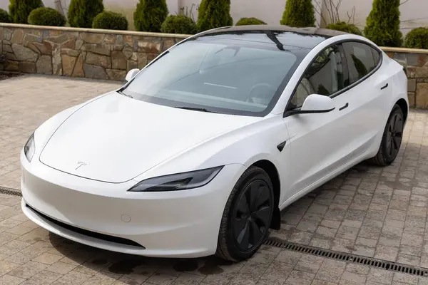 Lviv, Ukrayna - 23 Mart 2024: Beyaz Tesla Model 3 Highland elektrikli araba galeride, çağdaş Avrupa 'da EV kullanımındaki eğilimler, otomotiv endüstrisindeki son teknolojiler, çevresel sürdürülebilir.