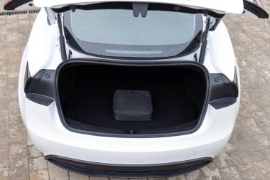 Arabanın bagajında duran elektrikli araba şarjı için taşınabilir kablo şarj kutusu. Arabanın bagajında elektrikli araba şarjı var. Şarj kablolarıyla bagaj. Modern iç mimari.