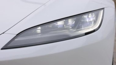 Lviv, Ukrayna - 23 Mart 2024: New Tesla Model 3 Highland elektrikli araba süper parlak ve modern LED matris far lambaları. Ön matris farları. Modern lüks arabanın far ışığı.