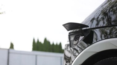 Kadın elinin alt görünümü elektrik veya EV arabaları şarj etmek için güç kablosu yerleştirir. Elektrikli araba ya da elektrik şarj istasyonunda EV fişi takan tanınmayan bir kadın..