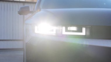 Sürekli yanıp sönen modern araba farları yanıp sönüyor. Araba Ön Ön Ön Ön Ön Ön Ön Ön Ön Ön Ön Ön Işık. Lüks arabanın ışıklarını açtı. Otomobil Yanıcı Işık.