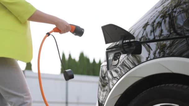 Woman Connects Electric Car Charger Adjusts Process Charging Car Battery — Wideo stockowe