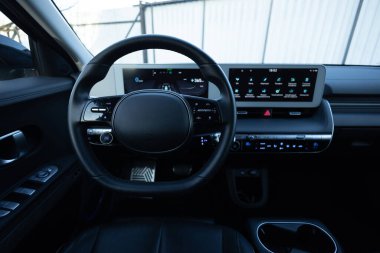 Yeni elektrikli bir aracın direksiyonunu kapat, iç kokpit, elektrik düğmeleri, dijital hız göstergesi. Elektrikli araba kontrol cihazları. Seyir kontrol düğmeleri, hız sınırı, arabalar sinyal.