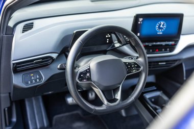 Siyah deri gösterge paneli, klima kontrolü, hız göstergesi, vitrin, ahşap süsleme. Direksiyon simidi. Pahalı elektrikli araba. Direksiyon simidi var..