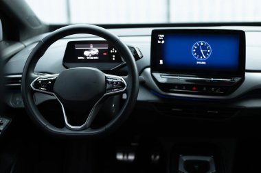 Close up of steering wheel of a new electric vehicle, interior cockpit, electric buttons, digital speedometer. Electric car control devices. Cruise control buttons, speed limitation, cars signal. clipart