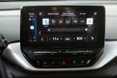 Isıtmalı koltukları tuşlara basarak çalıştırmak. Arabada ısıtmalı koltuk paneli. Direksiyon ısıtma düğmesi arabada. Direksiyon simidi ve koltuk ısıtıcısı olan elektrikli araba kontrol paneli.