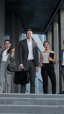 Happy 'nin gururlu profesyonel iş adamlarının dikey videosu kameraya bakıyor. Şirket takım portresi. Farklı nesillerden gülümseyen bir takım iş adamları kameraya bakıyor..