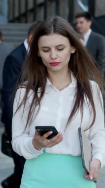 İş Bölgesi 'nde Genç Kadın Ofis Yöneticisinin Sosyal Medya Mesajları Yazarak Temyiz Ettiği Dikey Biçim Videosu. Başarı. İş adamları. Teknoloji.