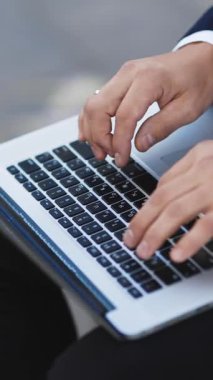 Freelancers 'ın ellerinin dizüstü bilgisayarda yazışının dikey videosu. İnternetle çalışan bir iş adamı. Adam internette yeni bir iş arıyor. İş konsepti. İşsizlik parası. İşsizlik yüzünden. Ekonomik kriz.