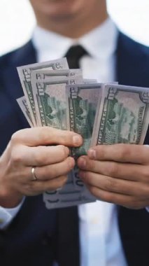 Dünya ekonomik krizinin dikey videosu. Para sayan İşadamı Ödeme Günü 'nde. Salgında tam bir işsizlik. Rüşvet. Kirli para. Başarılı bir iş. Başarı, kazanç, zafer sembolü.