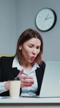 Stresli iş kadınının bilgisayarını kullanmaktan rahatsız olduğu dikey format videosu, bilgisayar sorunu yüzünden kızgın kadın veri kaybı, çevrimiçi hata, yazılım hatası veya sistem hatası yüzünden hayal kırıklığına uğramış.