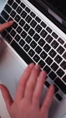 Ofisteki dizüstü bilgisayarda yazı yazan kadınların ellerini kapatın. Yakın çekim kapatıldı. O, dizüstü bilgisayarında klavye kullanıyor. Dikey Ekran Yönelimli Video Görüntüsü