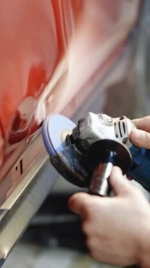 Dikey formatta, tamircinin işe başlamadan önce Angle Grinder ile boyayı çıkardığı video. Garajda bir araba kazası. Otomobil tamircisi otomobil kaportası öğütüyor