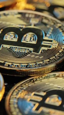 Altın Bitcoin 'lerin dikey format videosu. Yeni sanal para. Altın Bitcoin madenciliği. Sanal paralar anakart arka planında izole edilmiş. Şifreli para, bitcoin. BTC, Bit Coin. Engelleme teknolojisi