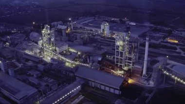 Geceleri endüstriyel çimento fabrikası. Alacakaranlıkta fabrikalar ve üretim tesisleri. Sanayi bölgesi, elektrik santrali. Üretim ürünleri. Elektrik santrali.