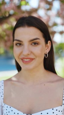 Yaratıcı makyajlı, dudaklarında pembe ruj ve kameraya bakarak poz veren güzel kadınların dikey format videosu. Kapalı portre Gülümseyen çekici yetişkin kadın