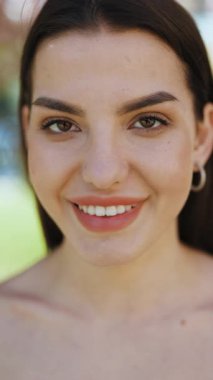 Dikey Format Portre Videosu Çekici bir yetişkin kadın modeli kameraya bakıyor, mutlu 20 'li yaşlarda güzel esmer kadın güzel dişçi yüzü gülüşü.