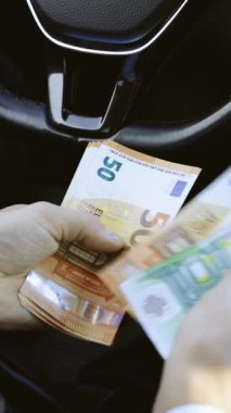 Avro banknotlarını sayan zengin adamın dikey format videosu. Para transferiyle ilgili bir iş anlaşması. Avro döviz kuru. Nakit para hesaplaması.