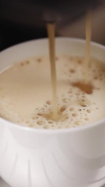Otomatik kahve makinesinin espresso içtiği dikey format videosu. Kahve makinesinde bir fincan koyu kahve yapıyorum. Kahve makinesinden espresso dökülüyor..