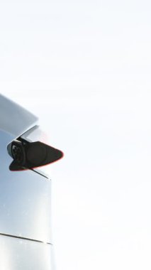 Elektrikli arabaları şarj eden adamın dikey videosu. Akıllı telefondaki uygulamayı kullanarak elektrik kablosunu elektrikli arabaya takan bir erkek. İş adamı açık hava şarj istasyonunda elektrikli araba yüklüyor.