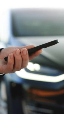 Mobil uygulama kullanarak otomatik çalışan bir elektrikli arabayı kontrol eden dikey video. Otonom otomatik pilot sürücüsüz araba. Akıllı telefon uygulaması. Algılayıcı tarama yolu ileride araçlar için, tehlike, hız limitleri