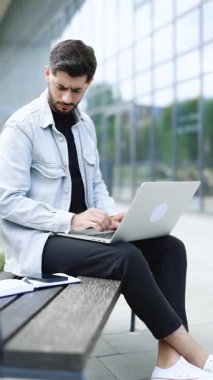 Mutlu iş adamının dikey format videosu cep telefonunda başarılar. Akıllı telefondan iyi haberleri ağır çekimde okuyan neşeli adam. Şaşırmış erkek akıllı telefondan zaferi kutluyor..