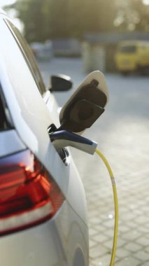 Elektrikli araca elektrik kablosu takan tanımlanamayan bir adamın dikey videosu. Erkek el EV araca güç bağlantısı yerleştirir ve şarj piller aktifleştirmek için akıllı kaset kullanır