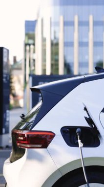 Vertical Format Video of Electric vehicle parking at the charging station. Electric vehicle battery cell recharging. Zero emission vehicle on EV only charging station is parked.