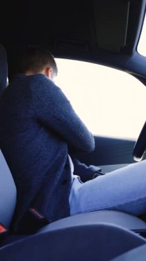 Arabanın emniyet kemeriyle vücudunun dikey videosu. Adam emniyet kemerini elle bağlıyor. Araba kullanmak için güvenlik kurallarına uymak. Araçlarda bir kişinin korunması. Yol güvenliği