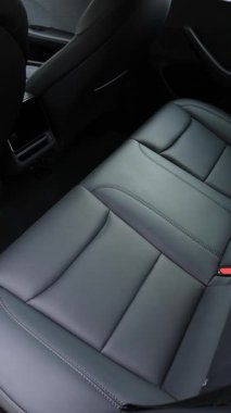 Tesla Model 3 Highland 'in dikey videosu. Lüks vagonda deri koltuklar. Deri araba yolcu koltuğu. Lüks arabadaki arka yolcular için medya sistemi. Lviv, Ukrayna - 23 Mart 2024
