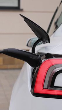 Elektrikli arabanın şarj olduğu dikey format video. Elektrikli araç modern EV 'yi şarj ediyor. Ekoloji alternatif enerjisini geleceğin sürdürülebilir enerjisinden koru. Elektrikli araba şarj portu.